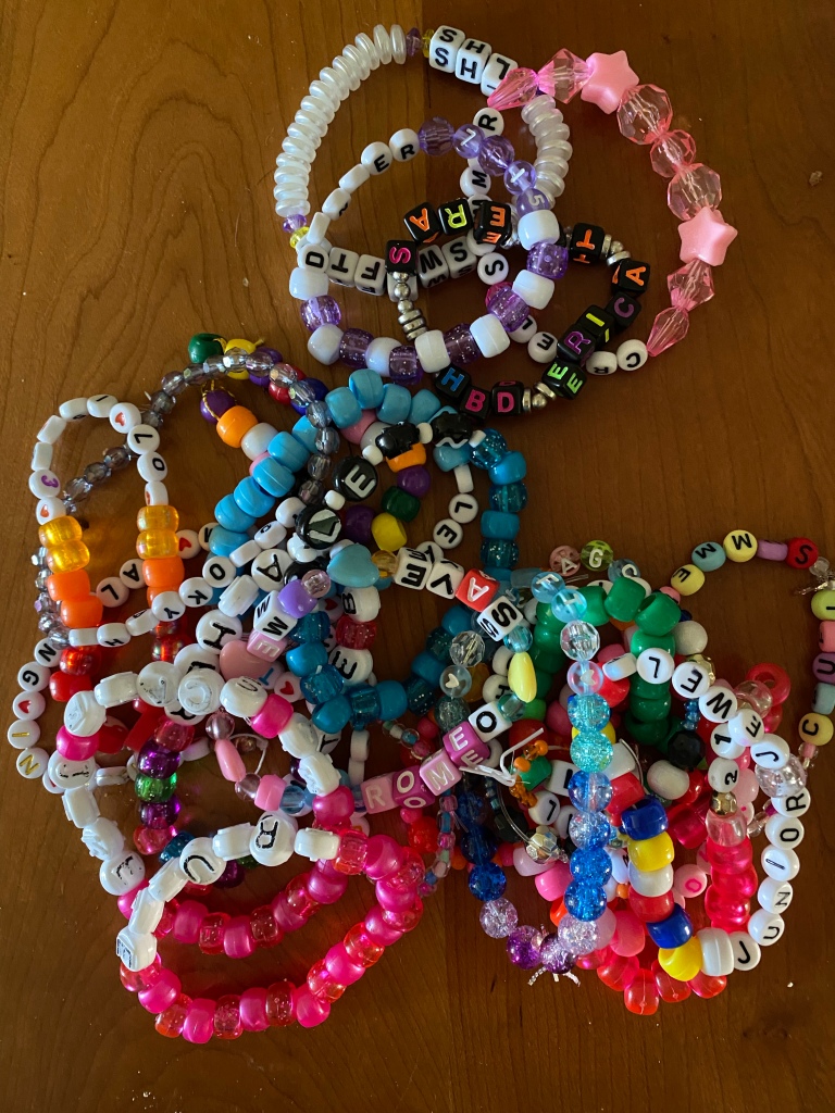 Friendship bracelets from the Taylor Swift Eras tour piled on a table.